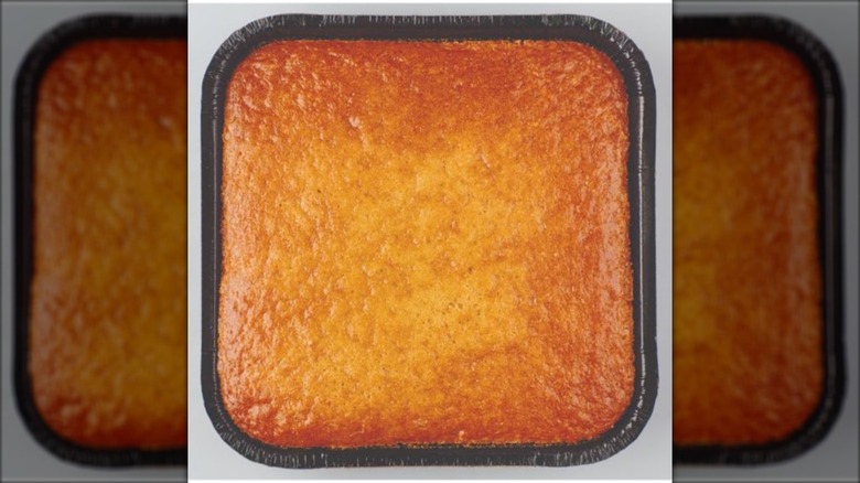 a golden cornbread in a black disposable pan