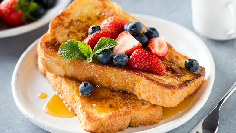 French toast with honey and berries on plate
