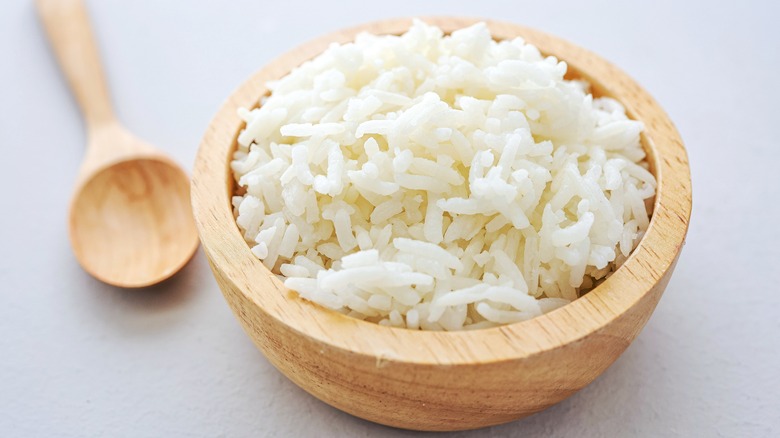 Cooked white rice in wood bowl closeup.