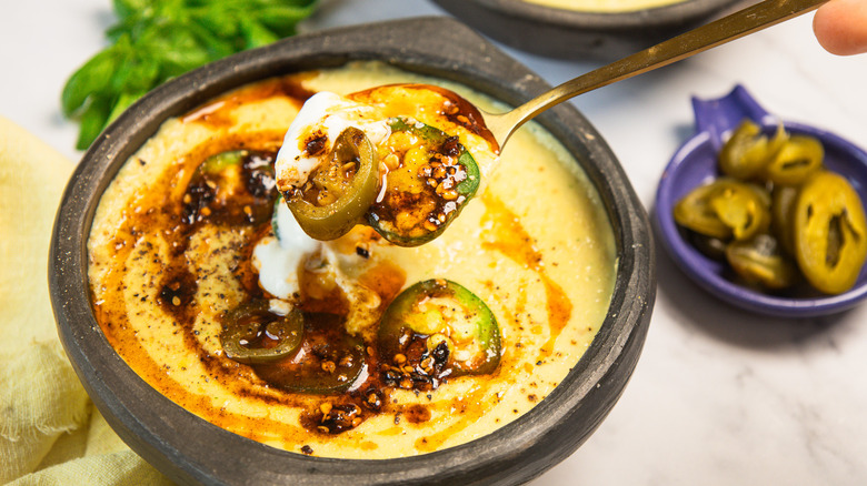 Lifting a spoonful out of a bowl of soup with jalapeño, crème fraîche, and chili crisp