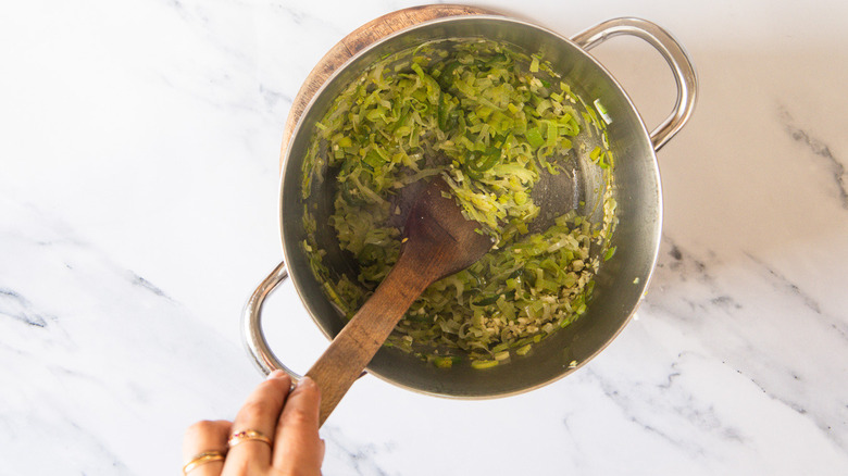Stirring leeks, jalapeno and garlic in soup pot