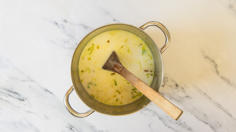 Soup with cream and wooden spoon
