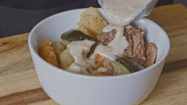 ladling sour cream gravy over vintage recipe pot roast