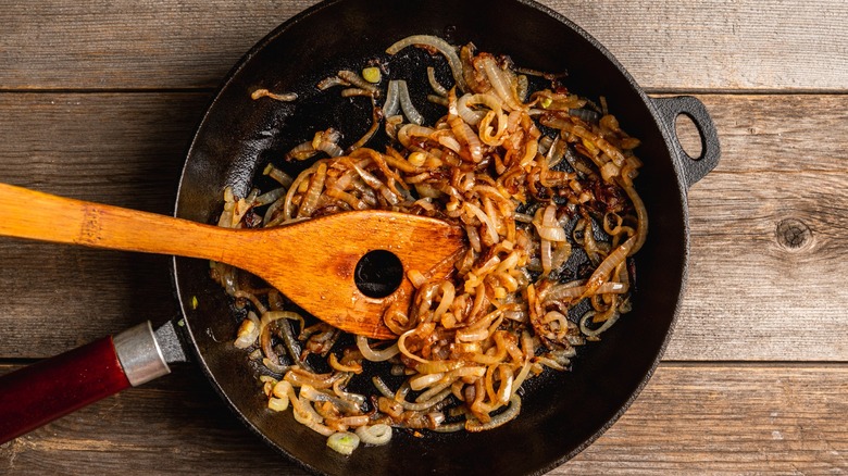 skillet of caramelized onions with wooden spoon