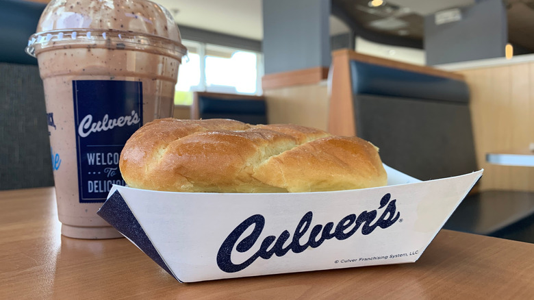 Closeup Culver's sandwich and drink in branded containers.