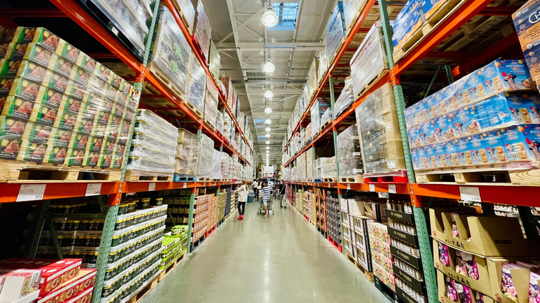 Customers shopping in large aisle of Costco warehouse