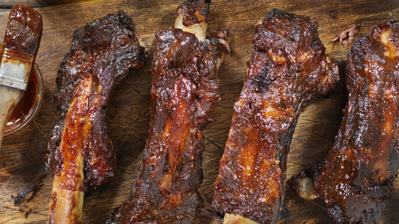 Closeup of beef ribs with barbecue sauce on top.
