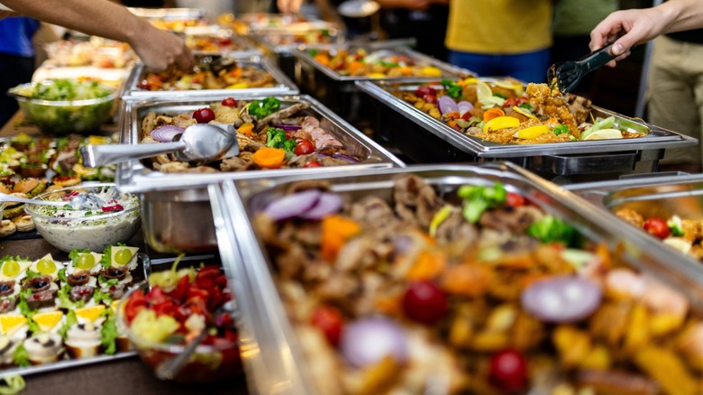 hands serve themselves from a lavish buffet spread