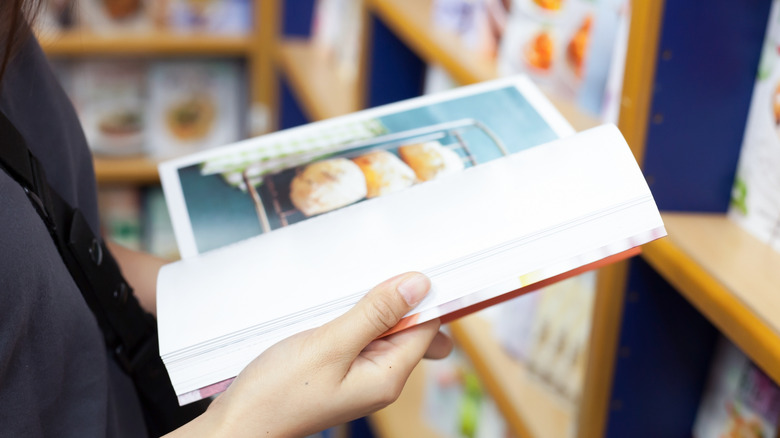Close up of someone browsing a cook book in a store