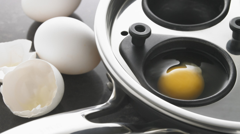 A close-up of a metal egg poaching pan