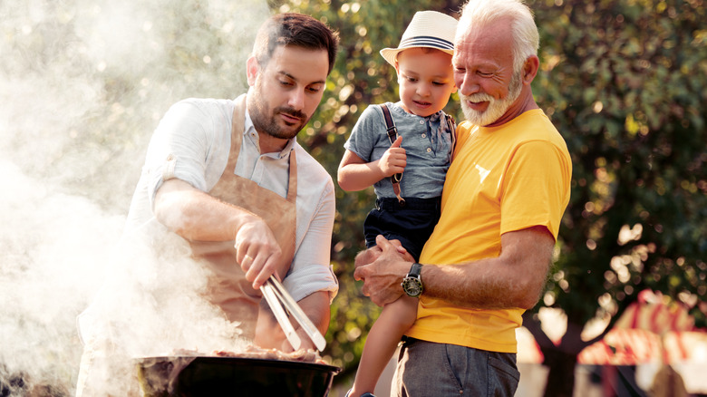 Two men standing near a barbecue