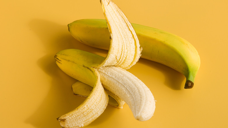 Two bananas on a yellow background