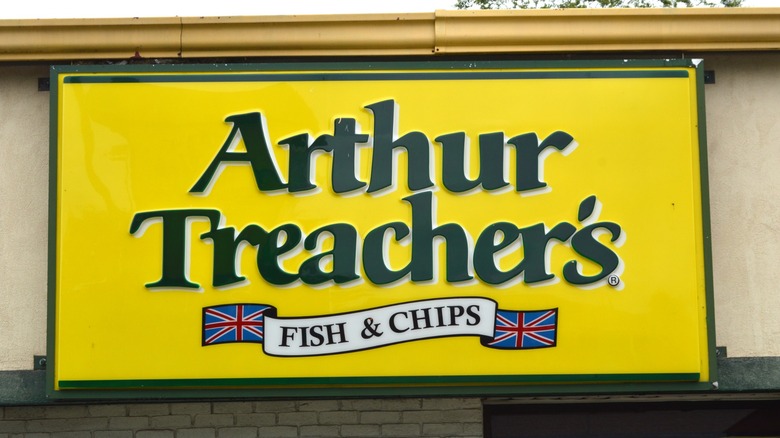 a yellow sign for arthur treacher's with union jack flags