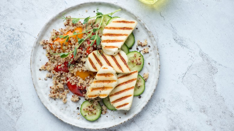 grilled halloumi cheese on a plate with quinoa salad.