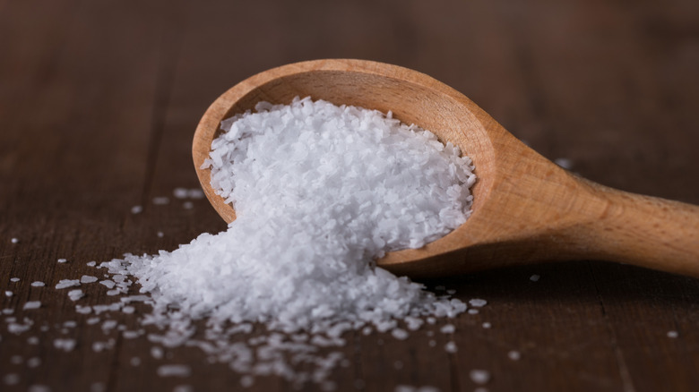 Salt spilling from a wooden spoon