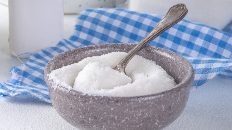 A grey bowl of allulose sweetener with a silver spoon in it
