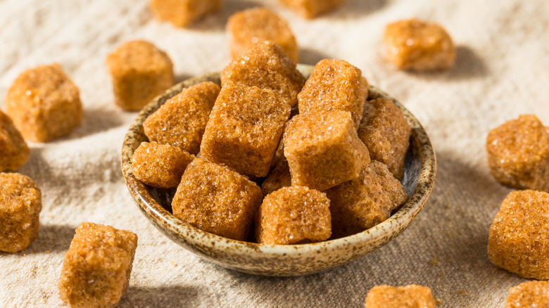 Brown sugar cubes in a bowl and on a table