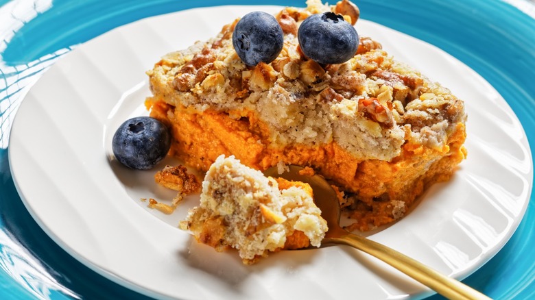 pumpkin dump cake with blueberries on white dish