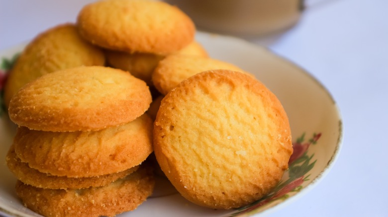 Closeup of butter cookies on floral plate, white tablecloth
