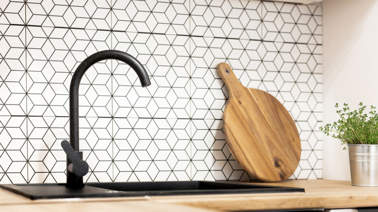 Kitchen with black and white geometric tiles.