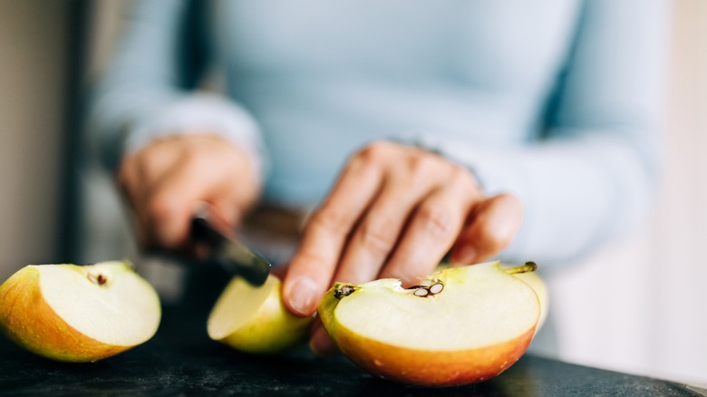 cutting an apple with a knife