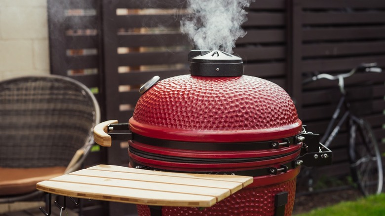 red kettle barbecue being used as a smoker outdoors