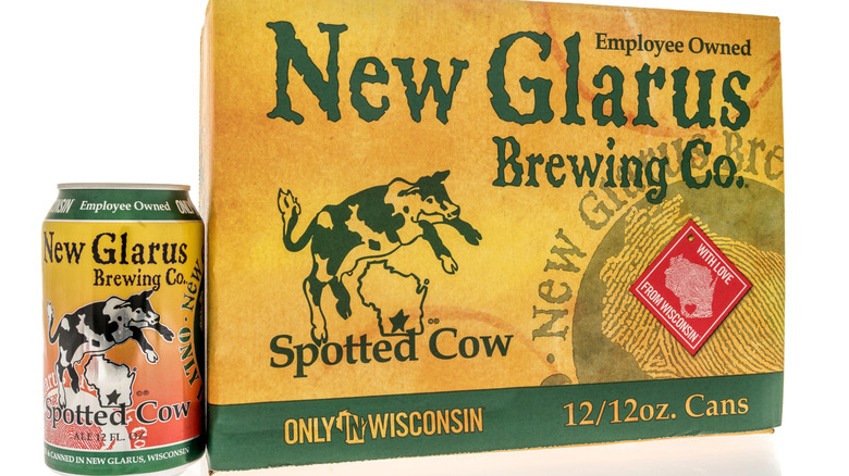 Can and six-pack box of New Glarus Spotted Cow beer on white background