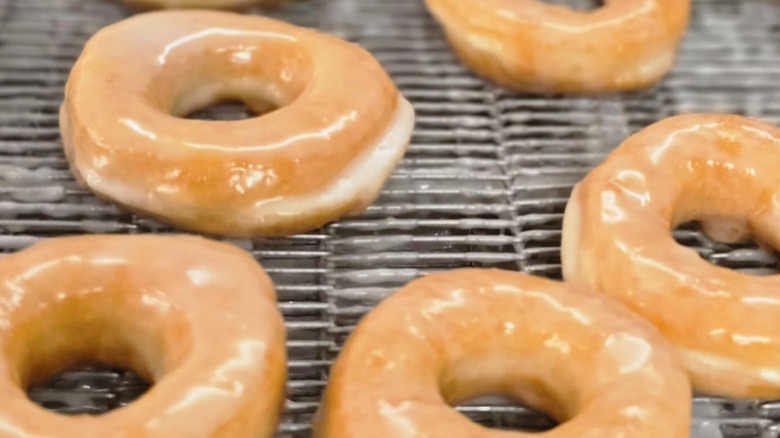Hot glazed donuts on a conveyor belt