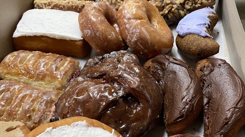 Cardboard box with baked goods like strudels, donuts, and cinnamon rolls