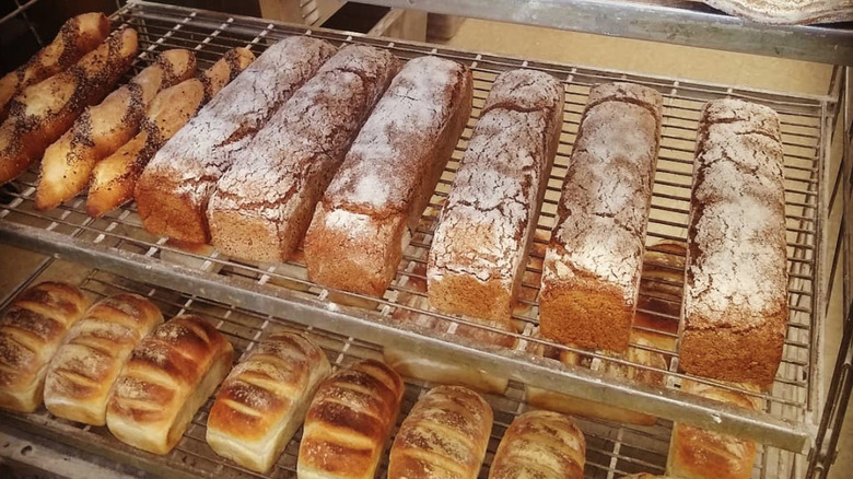 Racks of fresh baked breads and baguettes in a bakery