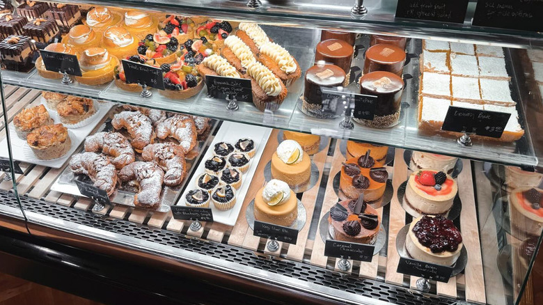 Bakery case with croissants, cakes, pastries, and tarts