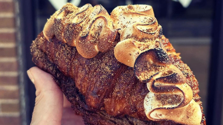 Hand holding a s'mores twice baked croissant outside