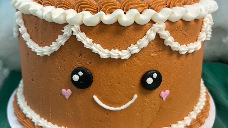 Layered cake iced and decorated to look like a gingerbread man face
