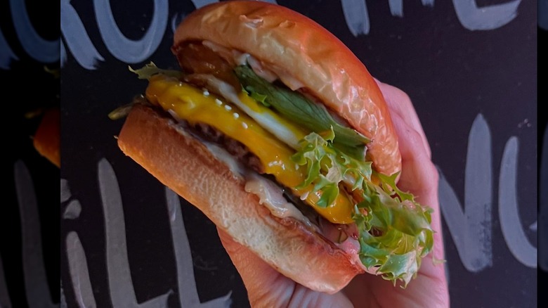 Someone holding a burger from Francis Burger Joint in Minnesota