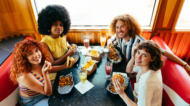 A group of friends sitting at a table at a diner