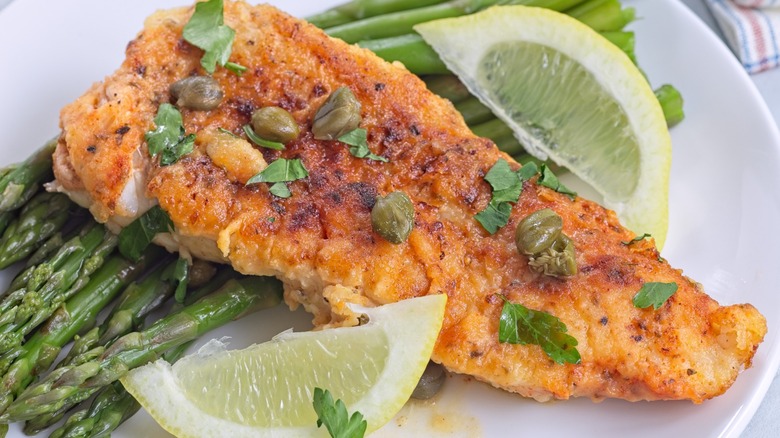 filet of fish with capers and lemon sauce served with asparagus