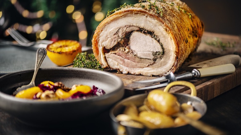 rolled pork loin with side dishes on holiday table