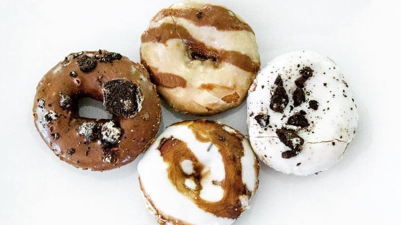 Four differently decorated donuts on white background