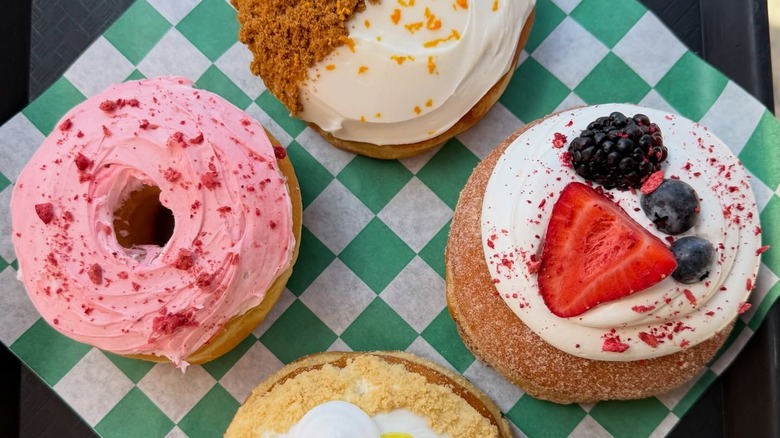 Four different donuts on green and white checkered paper