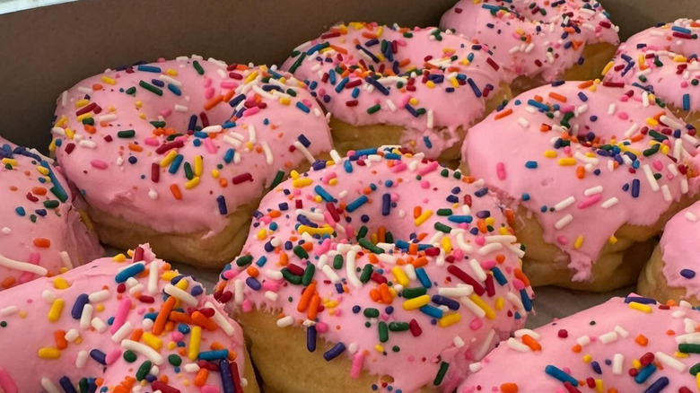 Box of pink sprinkled donuts