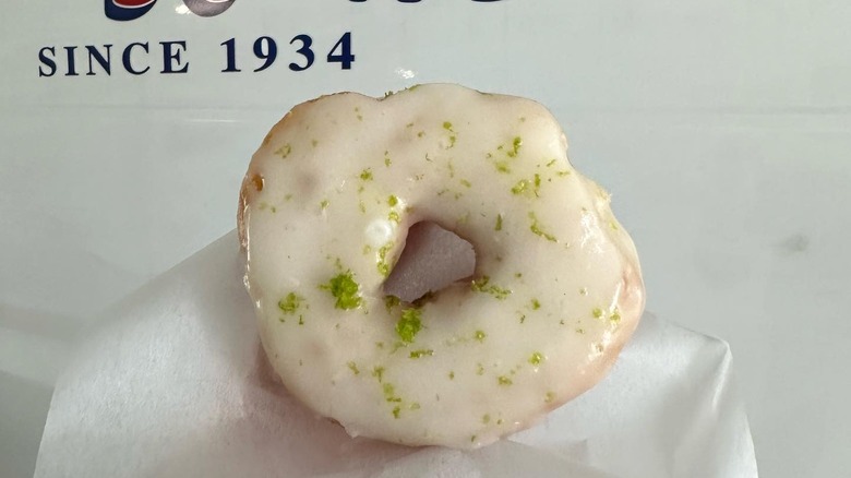 Lime glazed donut in front of store wall