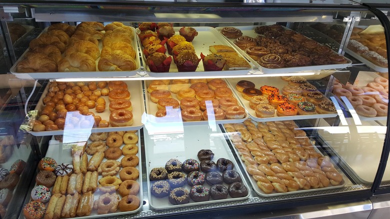 Bakery case with donuts, croissants, muffins, and cinnamon rolls