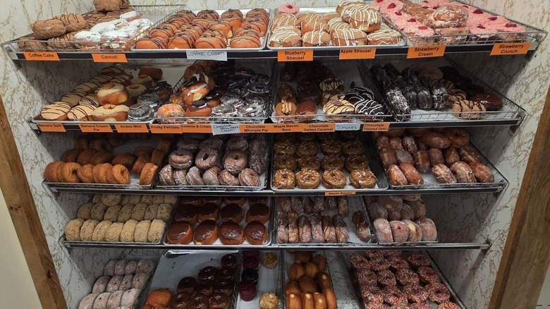 Open bakery racks with different donuts