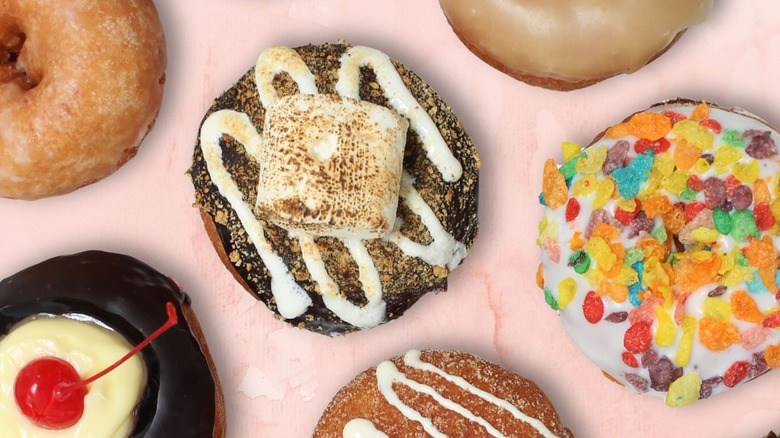Overhead image of assorted donuts on pale pink background