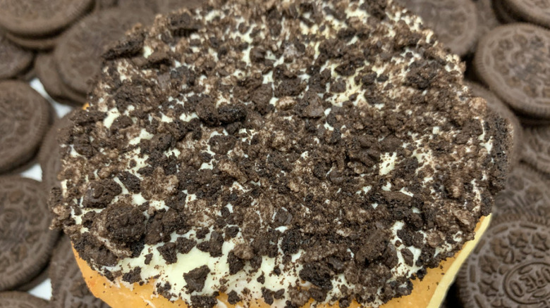 Oreo-covered filled donut on pile of Oreo cookies