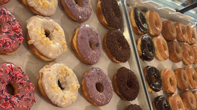Freshly glazed and decorated donuts on large baking sheets