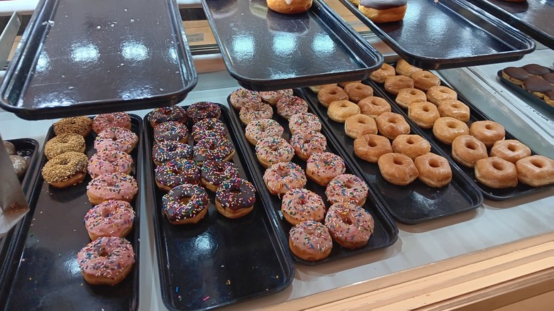 Bakery case showing trays of classic donuts