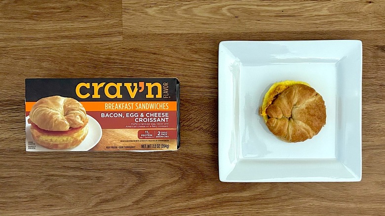 Package and cooked Crav'n Flavor Bacon, Egg, & Cheese Croissant on square white plate