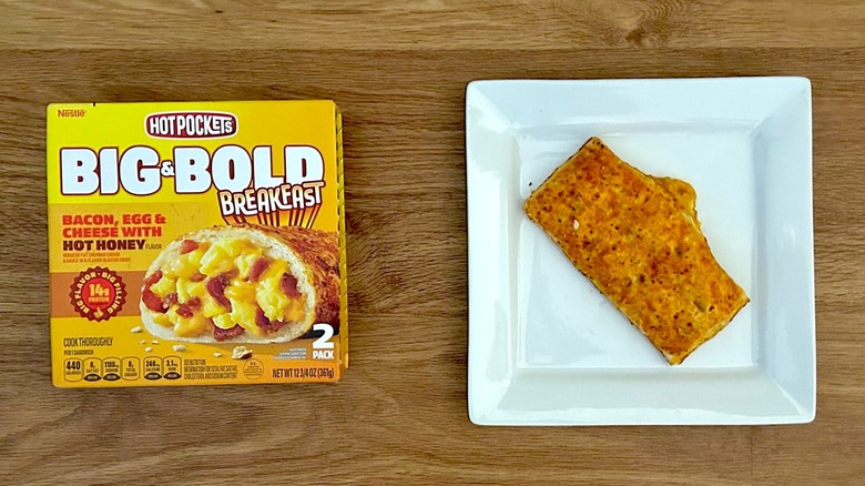 Package and cooked Hot Pockets Big & Bold Breakfast Bacon, Egg, & Cheese with Hot Honey Flavor on square white plate