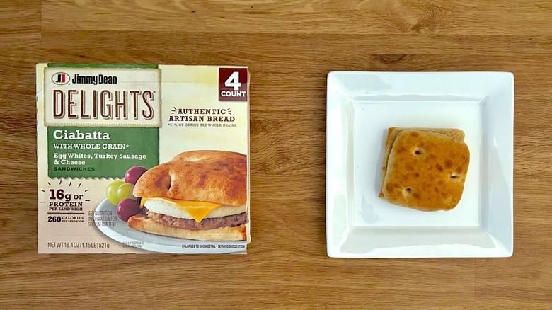 Package and cooked Jimmy Dean Delights Ciabatta Egg Whites, Turkey Sausage, & Cheese on square white plate